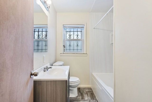 full bathroom featuring hardwood / wood-style floors, vanity, toilet, and shower / washtub combination