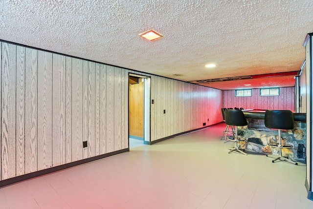 office with a textured ceiling and wood walls