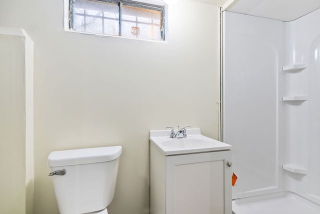 bathroom featuring vanity, toilet, and a shower