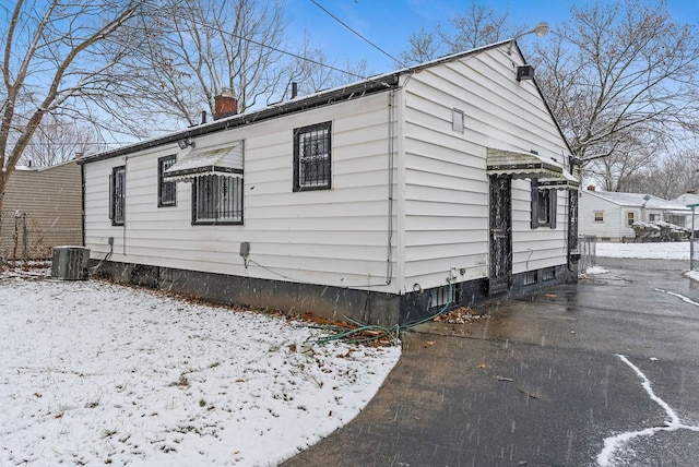 snow covered property featuring cooling unit