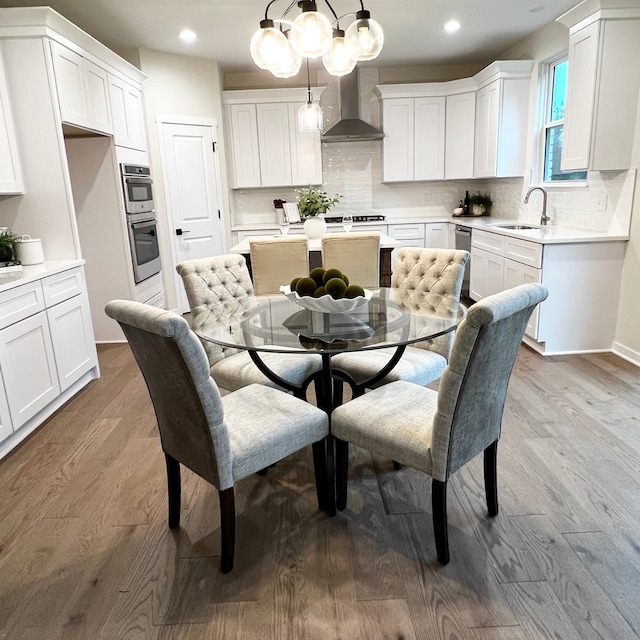 dining space with light wood-type flooring and sink