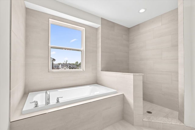 bathroom featuring separate shower and tub and tile walls