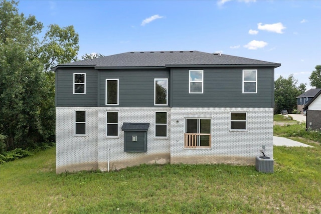 back of property with cooling unit and a lawn