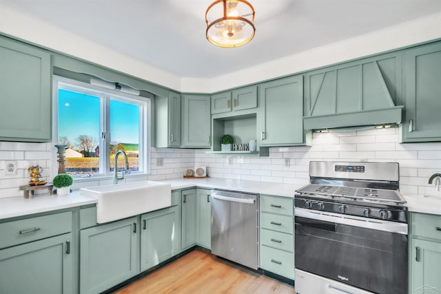 kitchen with appliances with stainless steel finishes, sink, green cabinetry, and custom exhaust hood