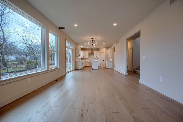 unfurnished living room featuring light wood-type flooring and a notable chandelier