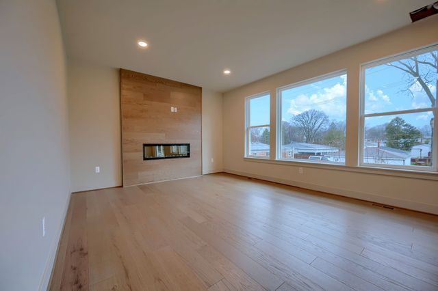 unfurnished living room with a wealth of natural light, a fireplace, and light wood-type flooring