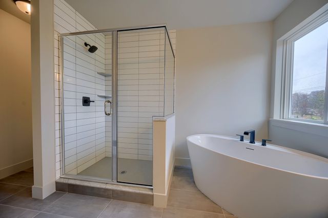 bathroom with tile patterned floors, a healthy amount of sunlight, and shower with separate bathtub