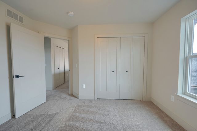 unfurnished bedroom featuring light carpet and a closet