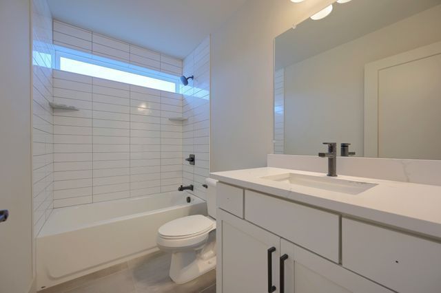 full bathroom featuring tile patterned floors, vanity, toilet, and tiled shower / bath