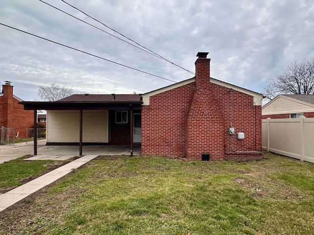 back of property with a lawn and a patio