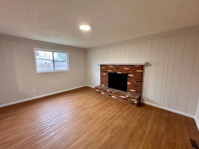 unfurnished living room with a fireplace and wood-type flooring