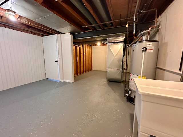 basement featuring heating unit, sink, and gas water heater