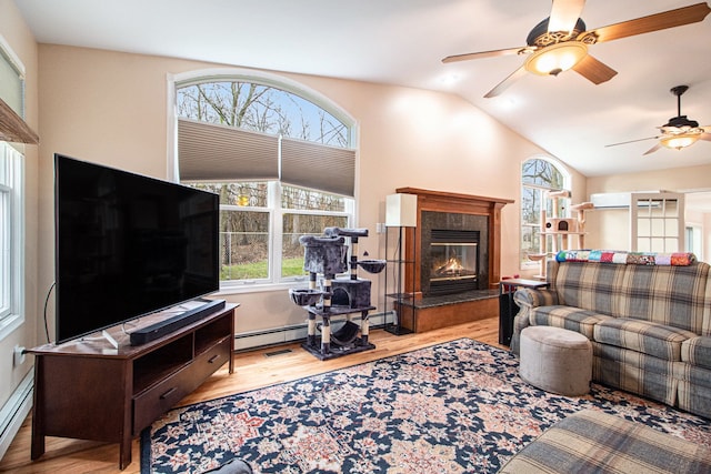 living room featuring ceiling fan, light hardwood / wood-style floors, lofted ceiling, and a baseboard heating unit