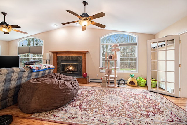 living room featuring vaulted ceiling, light hardwood / wood-style flooring, a wall mounted AC, and a premium fireplace