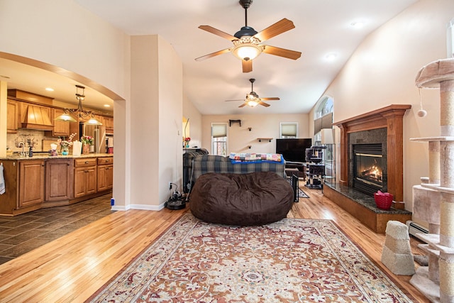 living room with ceiling fan, a fireplace, and light hardwood / wood-style floors