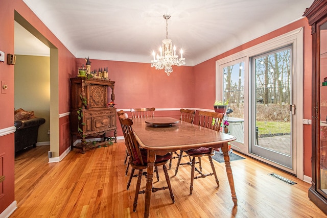 dining area featuring light hardwood / wood-style floors and a notable chandelier