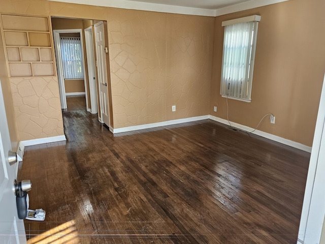 unfurnished room with a wealth of natural light and dark wood-type flooring