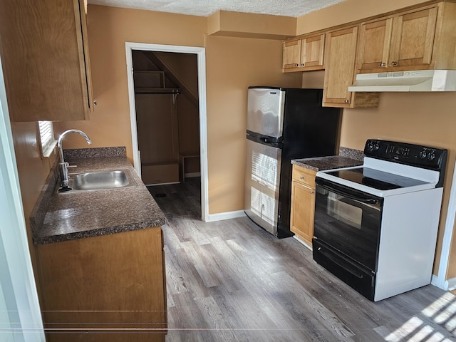 kitchen featuring a textured ceiling, sink, white electric range, hardwood / wood-style floors, and stainless steel refrigerator