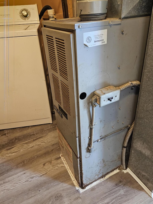 interior details featuring washer / clothes dryer, wooden walls, heating unit, and wood-type flooring