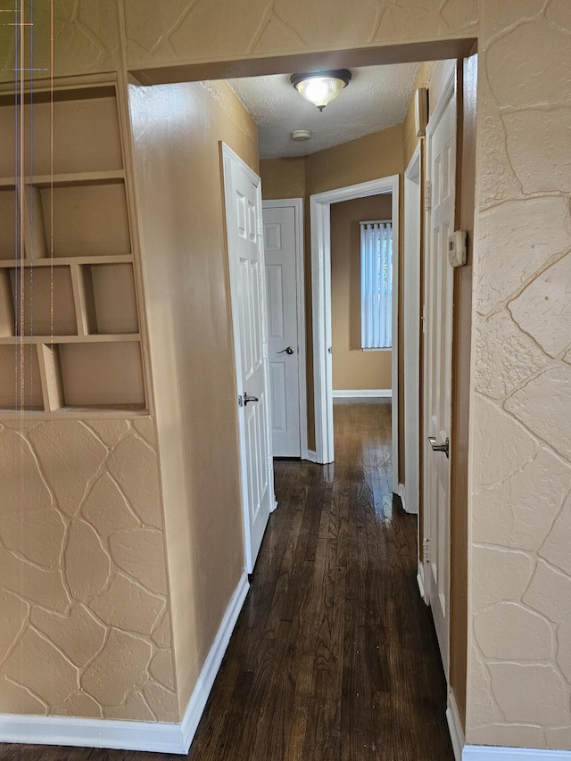 hall featuring dark hardwood / wood-style flooring and a textured ceiling