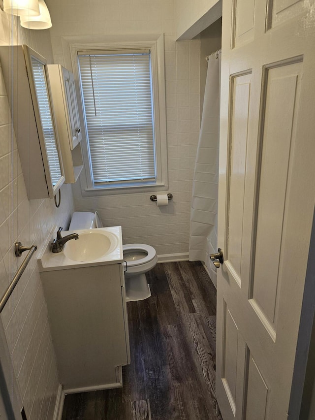 bathroom featuring wood-type flooring, vanity, toilet, and curtained shower