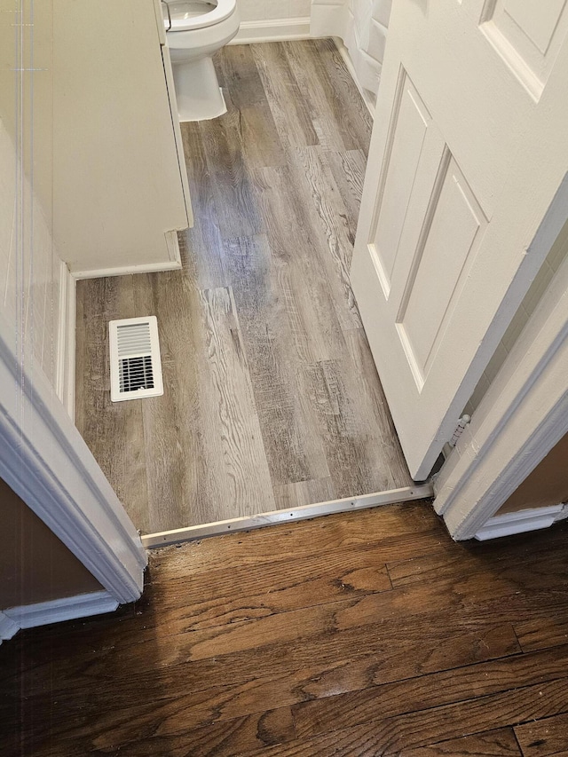 interior space with wood-type flooring and toilet