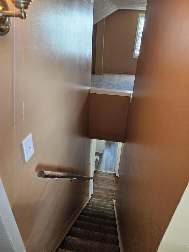 stairs with hardwood / wood-style flooring and vaulted ceiling