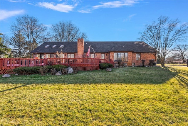 rear view of property featuring a lawn and a deck