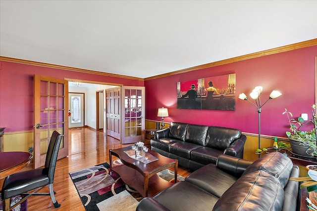 living room featuring french doors, ornamental molding, and hardwood / wood-style floors