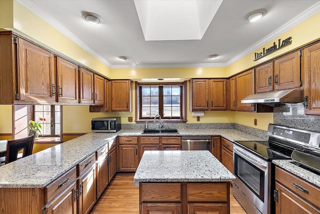 kitchen featuring stainless steel appliances, a kitchen island, ornamental molding, and light stone counters