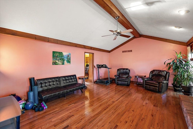 living room featuring hardwood / wood-style floors, vaulted ceiling with beams, a textured ceiling, and ceiling fan