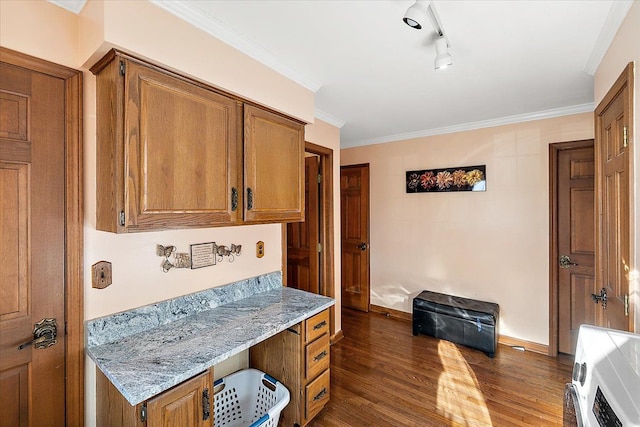 interior space with dark hardwood / wood-style flooring, rail lighting, ornamental molding, heating unit, and built in desk