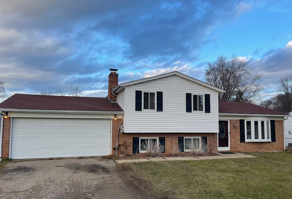 tri-level home with a garage and a front lawn