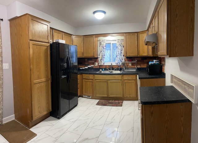 kitchen with exhaust hood, backsplash, black refrigerator with ice dispenser, and sink