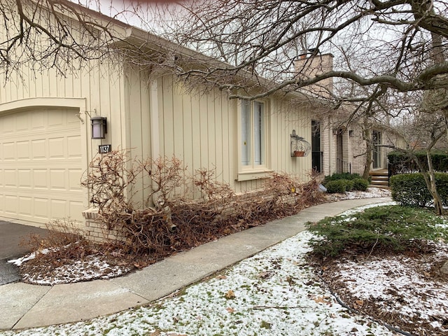 view of snow covered exterior with a garage