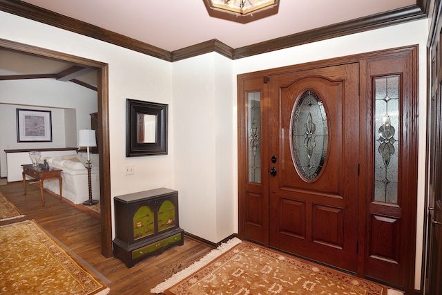 foyer entrance featuring lofted ceiling, hardwood / wood-style flooring, and ornamental molding