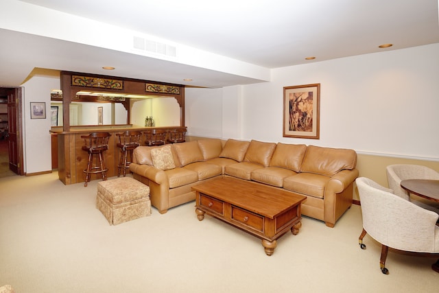 living room with light colored carpet and bar