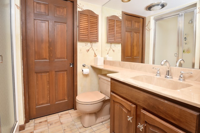 bathroom featuring vanity, toilet, and a shower with shower door