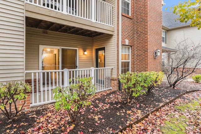 view of exterior entry featuring a balcony