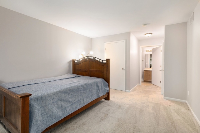 carpeted bedroom featuring ensuite bath