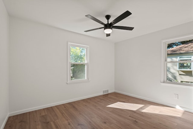 empty room with ceiling fan and light hardwood / wood-style floors