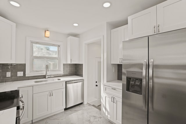 kitchen with white cabinets, decorative backsplash, sink, and stainless steel appliances