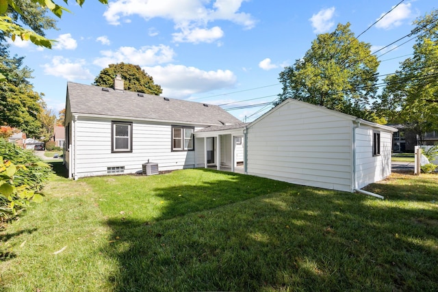 rear view of house featuring a yard and central air condition unit