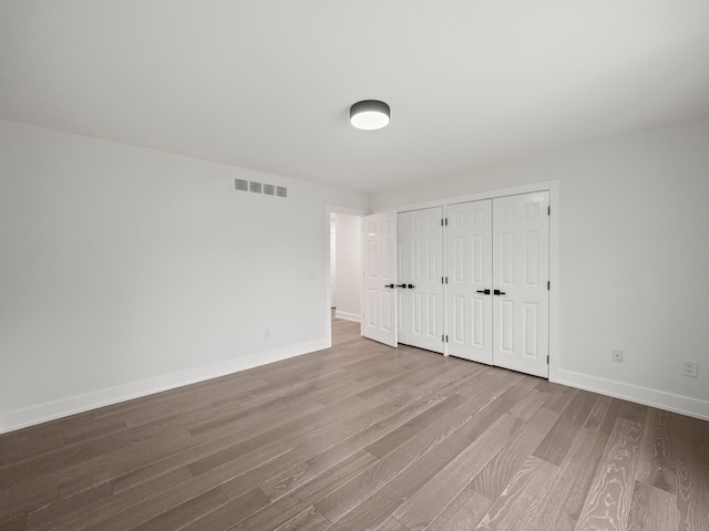 unfurnished bedroom with light wood-type flooring and a closet