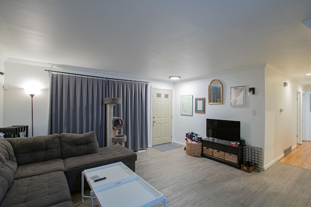 living room featuring hardwood / wood-style floors and crown molding