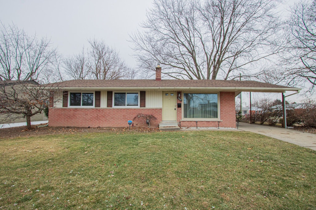 ranch-style home featuring a front yard and a carport