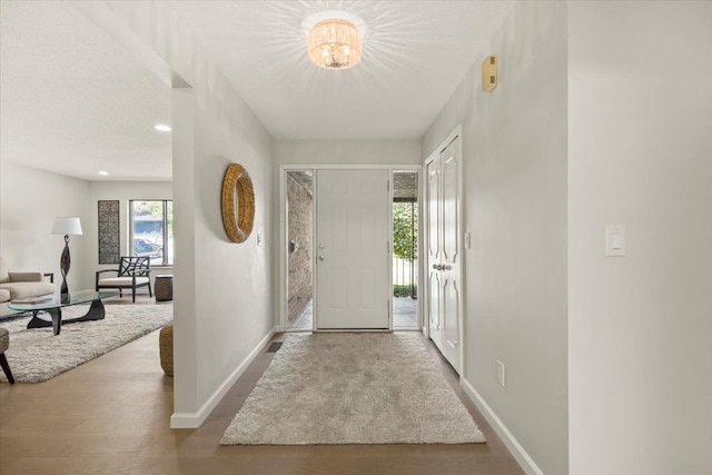 entryway featuring an inviting chandelier and light wood-type flooring