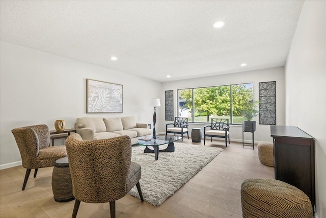 living room featuring a textured ceiling and light wood-type flooring