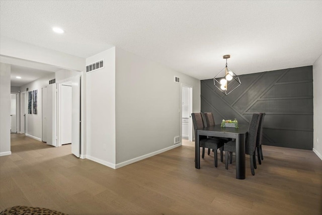 dining space with a textured ceiling and hardwood / wood-style flooring