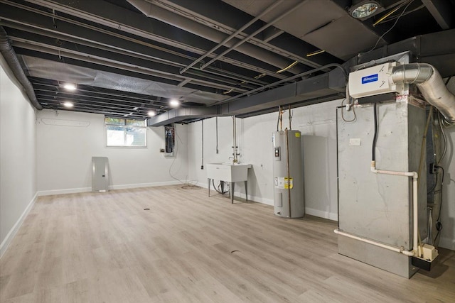 basement featuring sink, light wood-type flooring, heating unit, and water heater